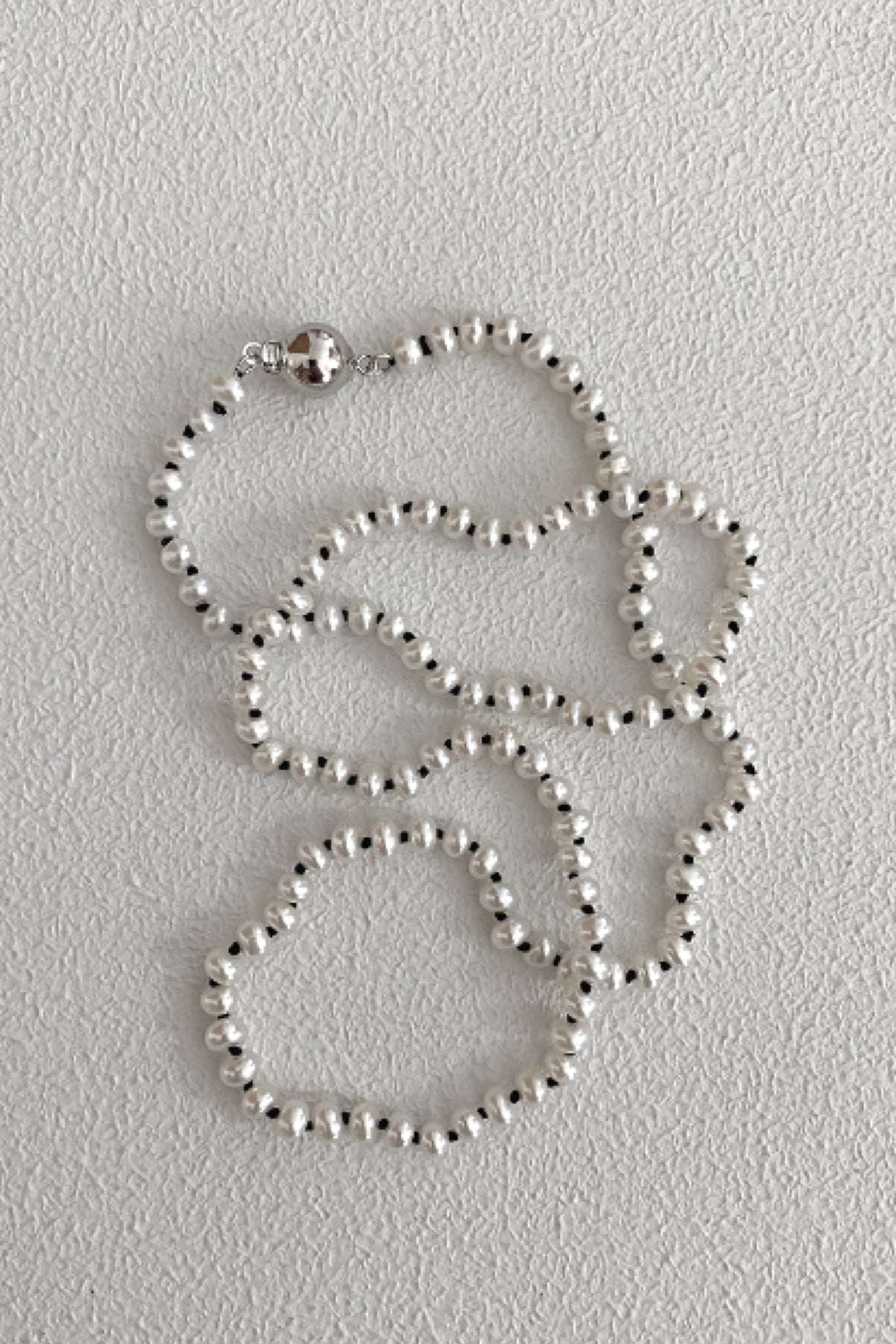 Collier de perles avec fil noir |